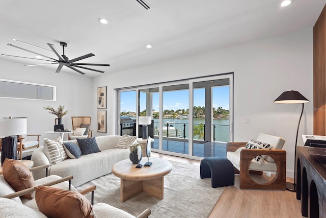 living room featuring a water view and light hardwood / wood-style flooring