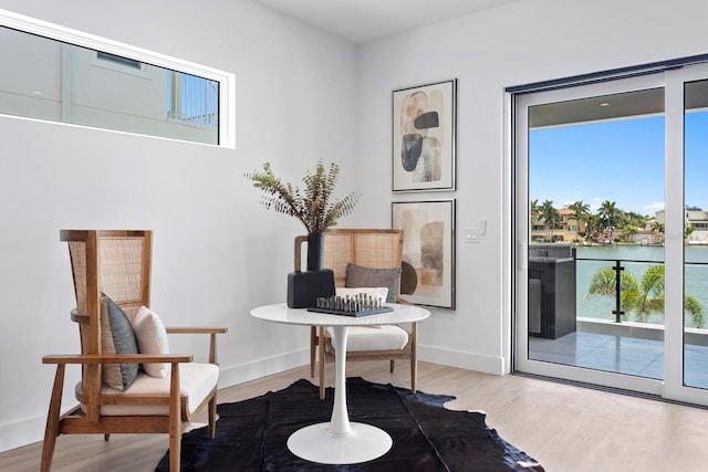 sitting room with wood-type flooring and a water view