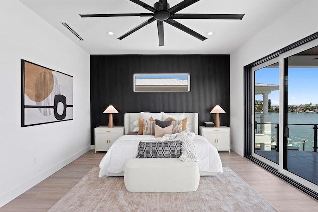 bedroom featuring a water view, access to outside, ceiling fan, and light hardwood / wood-style floors