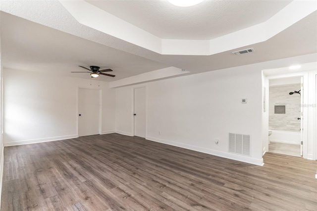 empty room featuring a textured ceiling, wood-type flooring, and ceiling fan