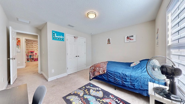 bedroom featuring light carpet and a textured ceiling