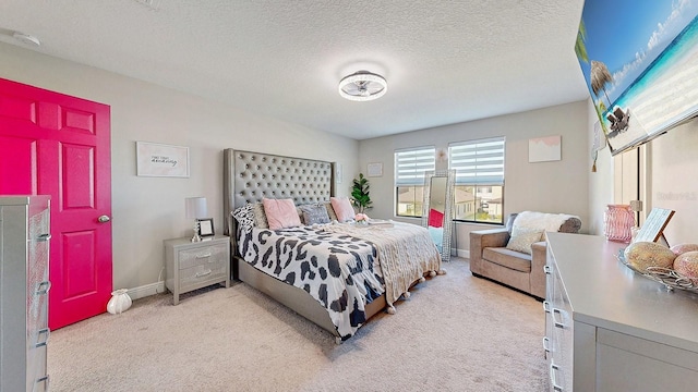 bedroom featuring light colored carpet and a textured ceiling