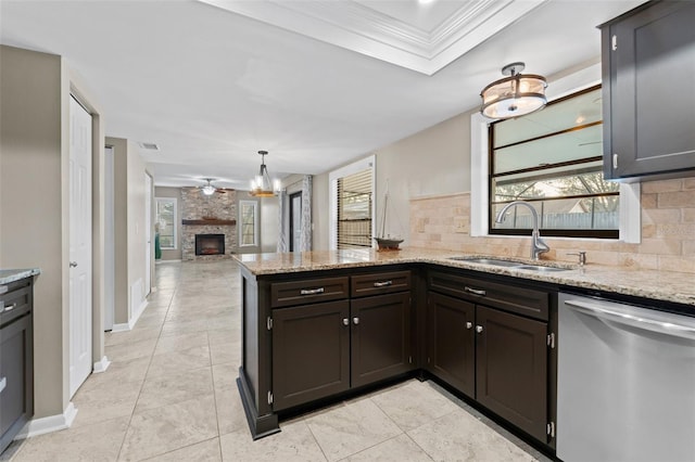 kitchen with sink, tasteful backsplash, stainless steel dishwasher, a fireplace, and ornamental molding