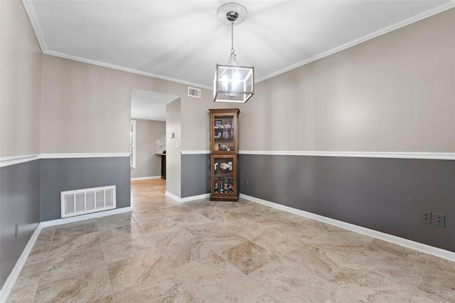 spare room featuring a notable chandelier and crown molding