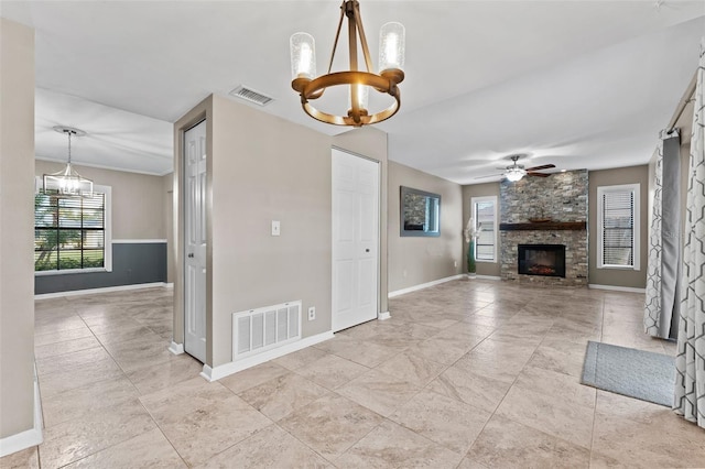 unfurnished living room featuring a fireplace and ceiling fan with notable chandelier