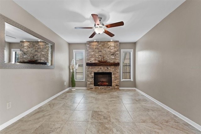 unfurnished living room featuring a stone fireplace, ceiling fan, and a healthy amount of sunlight