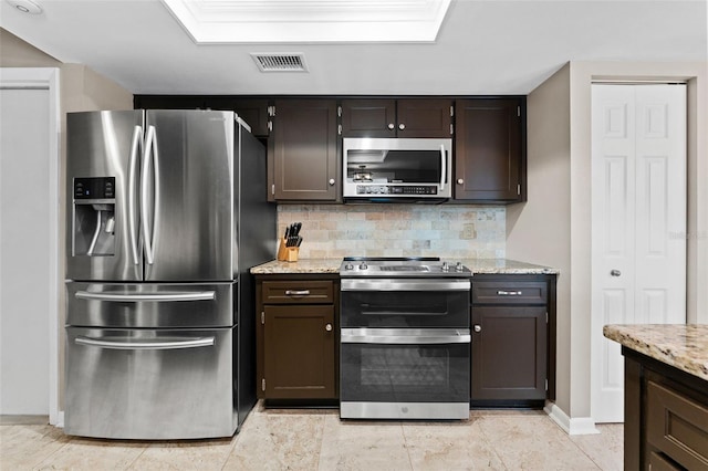 kitchen with decorative backsplash, appliances with stainless steel finishes, dark brown cabinetry, and light stone countertops