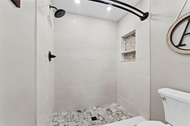 bathroom featuring toilet and tiled shower