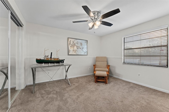 sitting room featuring light carpet and ceiling fan