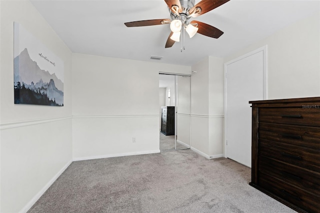 unfurnished bedroom featuring ceiling fan, light carpet, and a closet