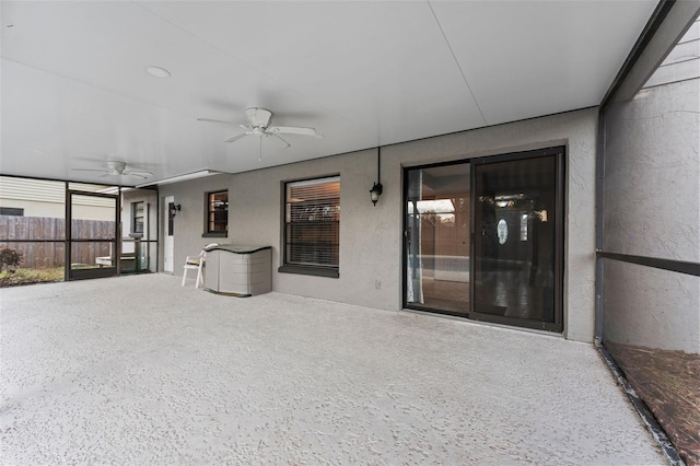 unfurnished sunroom featuring ceiling fan