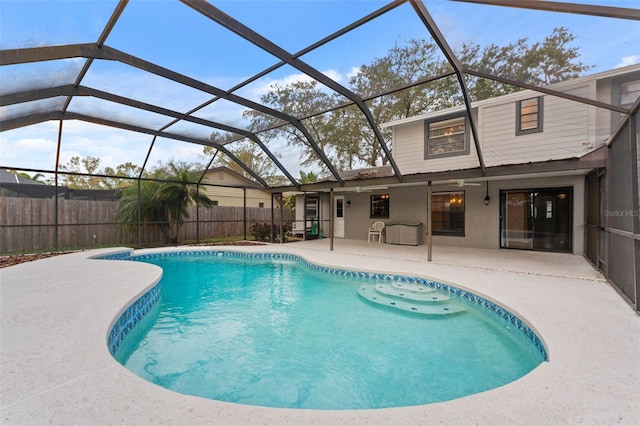 view of swimming pool with glass enclosure and a patio