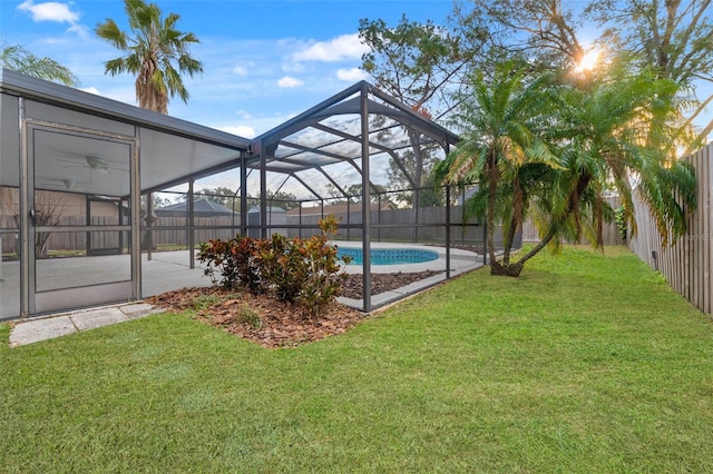 view of swimming pool with a yard and glass enclosure