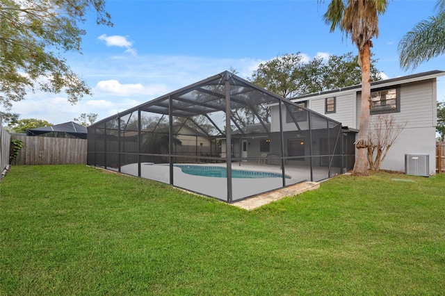 view of pool featuring a lawn, glass enclosure, and central AC