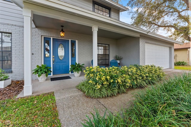 entrance to property with covered porch and a garage