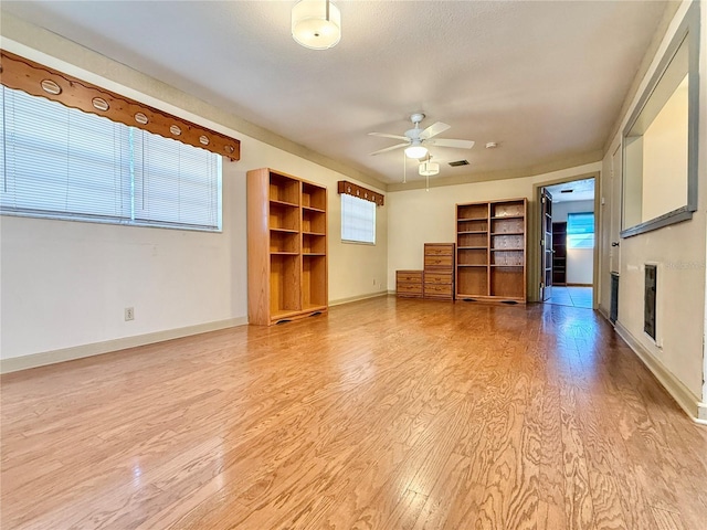 unfurnished living room with light wood-type flooring and ceiling fan