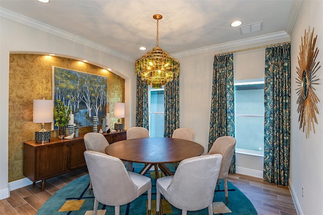 dining area with crown molding and a chandelier