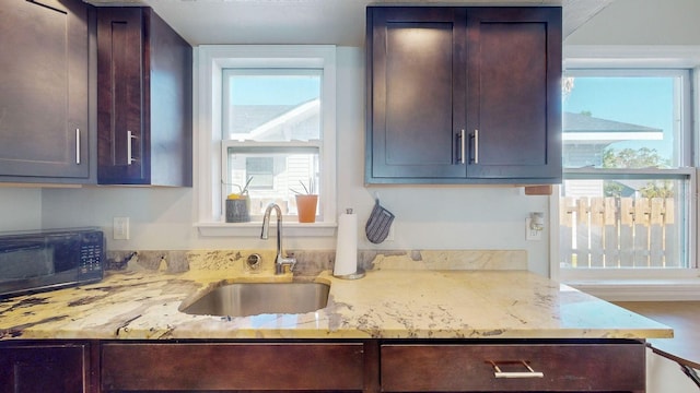 kitchen featuring light stone countertops and sink