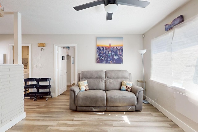 living room featuring ceiling fan and light hardwood / wood-style floors