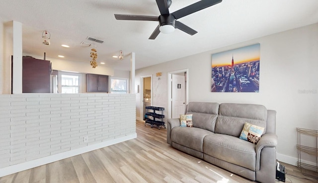 living room featuring ceiling fan and light wood-type flooring