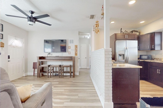 kitchen featuring dark brown cabinets, stainless steel fridge, ceiling fan, and light hardwood / wood-style flooring