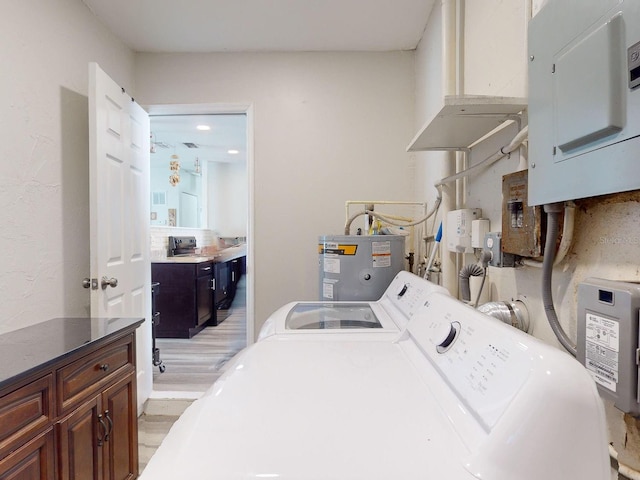 laundry area with cabinets, water heater, light hardwood / wood-style flooring, independent washer and dryer, and electric panel