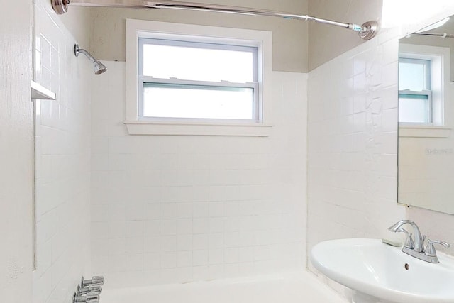 bathroom with sink and tiled shower / bath