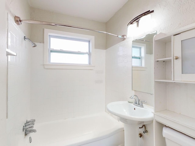 bathroom with tiled shower / bath combo and toilet