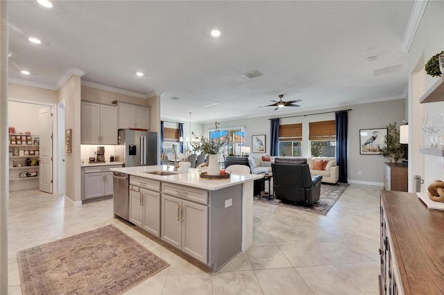 kitchen featuring a kitchen island with sink, sink, ceiling fan, gray cabinets, and appliances with stainless steel finishes