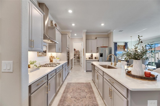 kitchen with gray cabinetry, sink, wall chimney range hood, crown molding, and appliances with stainless steel finishes