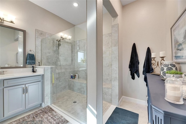 bathroom with tiled shower, vanity, and tile patterned flooring