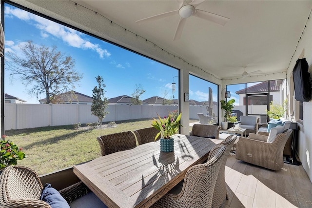 sunroom / solarium featuring a wealth of natural light and ceiling fan