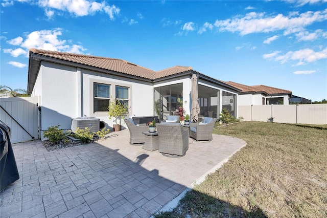 back of house featuring a sunroom, an outdoor living space, a yard, central AC unit, and a patio area