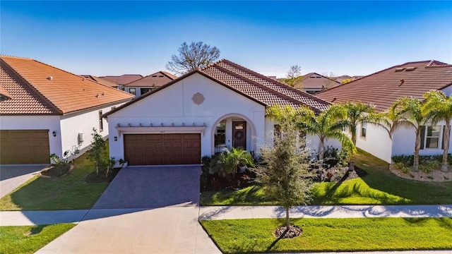 mediterranean / spanish house featuring a front yard and a garage