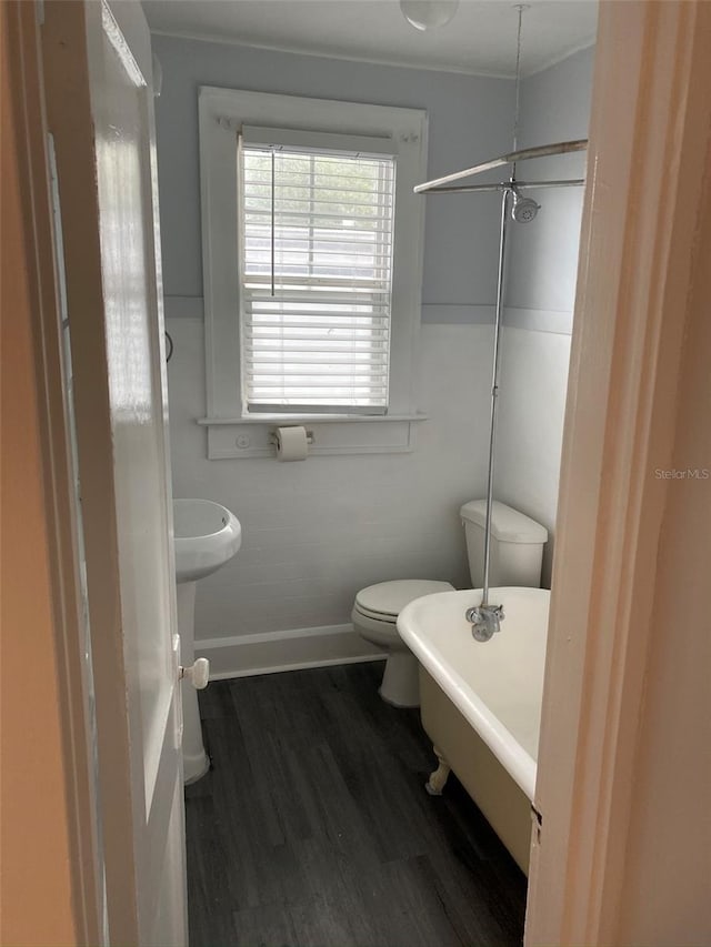 bathroom with a bathing tub, wood-type flooring, and toilet