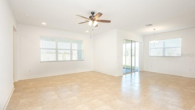 unfurnished room with ceiling fan with notable chandelier