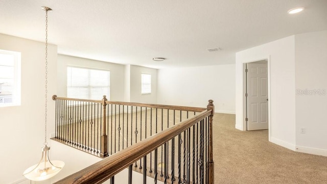 hall with light colored carpet