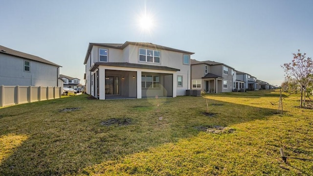 back of property with a lawn, central AC unit, and a sunroom