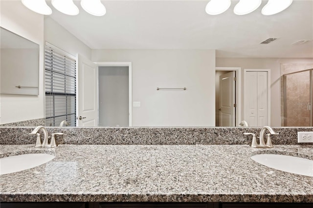 bathroom with vanity and a shower with door