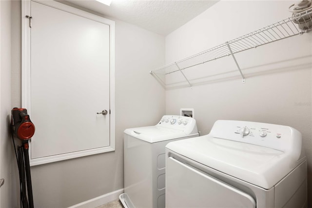 washroom with a textured ceiling and washing machine and clothes dryer