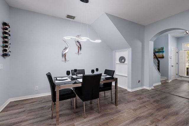 dining area with built in features and dark hardwood / wood-style floors