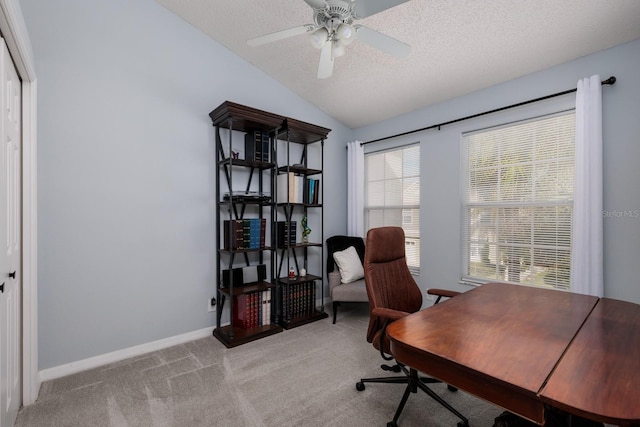 carpeted office with a textured ceiling, vaulted ceiling, and ceiling fan