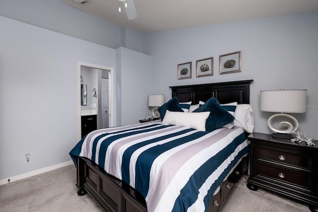 bedroom featuring light carpet, vaulted ceiling, ensuite bath, and ceiling fan