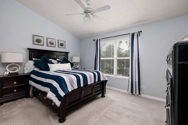 carpeted bedroom with a textured ceiling, multiple windows, ceiling fan, and vaulted ceiling