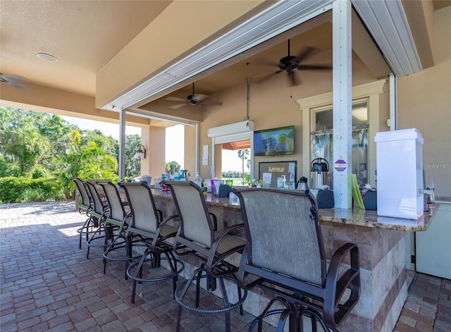 view of patio featuring a bar and ceiling fan