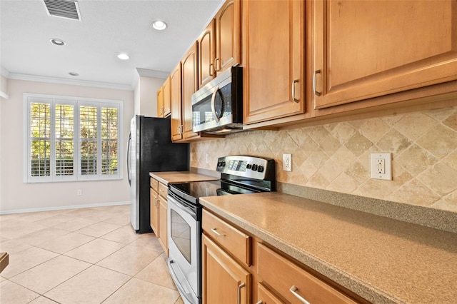 kitchen featuring backsplash, crown molding, light tile patterned floors, and appliances with stainless steel finishes