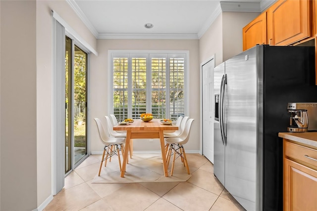 kitchen featuring stainless steel fridge, ornamental molding, and light tile patterned flooring