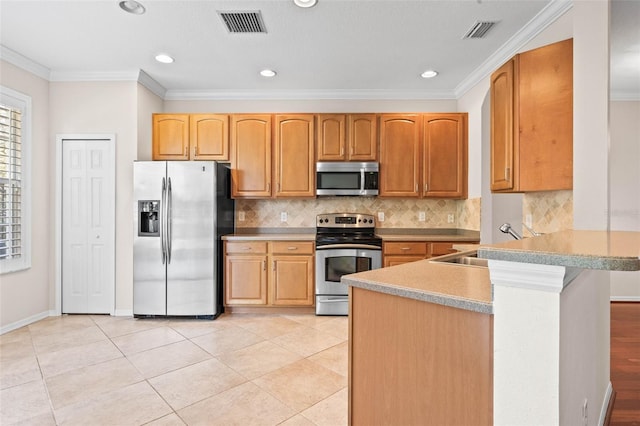 kitchen with backsplash, sink, ornamental molding, appliances with stainless steel finishes, and light tile patterned flooring