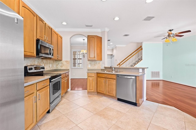 kitchen with crown molding, sink, ceiling fan, appliances with stainless steel finishes, and tasteful backsplash