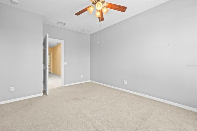 spare room with ceiling fan and light carpet